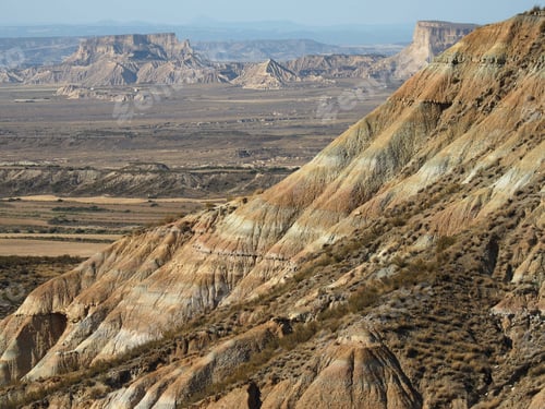 Preview: Shot of rocks and deserted sandy fields seen over the side of a mountain