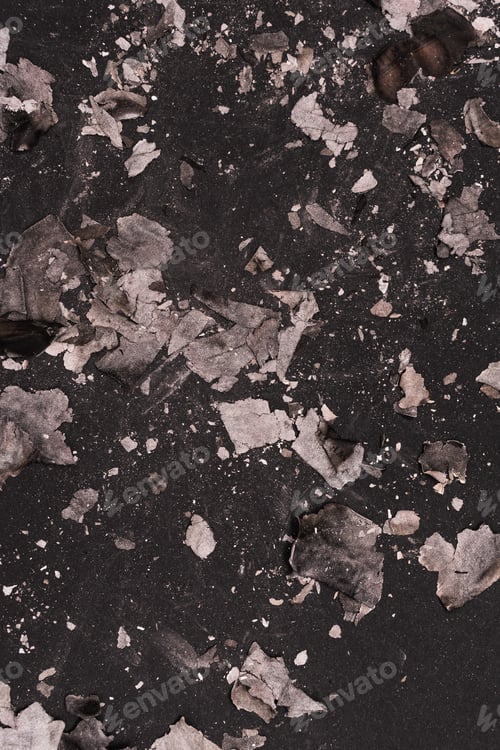 Preview: Scattered burnt ashes and debris on a dark background