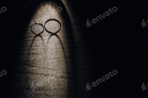 Preview: Close-up of two gold wedding rings on a black background