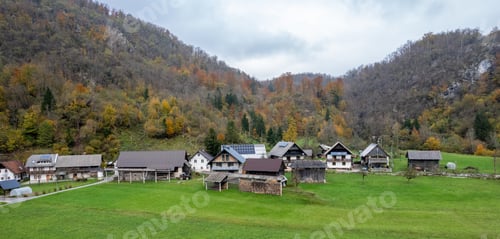 Preview: Idyllic mountain village with houses using solar panels in autumn, slovenia