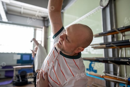 Preview: Focused attentive rower training warm up, do side bends before rowing session in gym. Healthy hobby