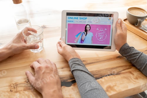 Visualização: Jovem mulher segurando tablet digital com a página inicial da loja online em sua tela