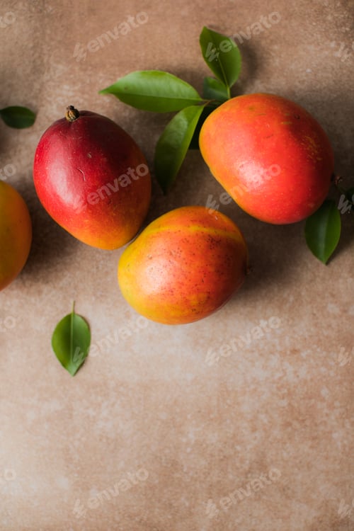 Preview: Mango background design concept. Top view of fresh mango fruit pattern with leaves on table.