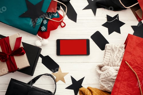 Preview: Phone with empty screen, bags, clothes and shoes, gift boxes