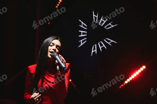Preview: Female singer performing live on stage with microphone
