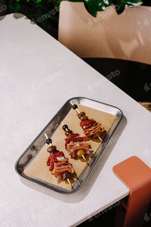 Preview: Grilled skewers of meats and vegetables served on a tray in a cozy restaurant