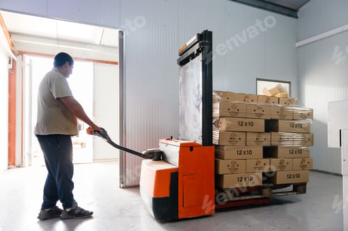 Preview: Man operating a forklift with cardboard boxes in factory facility