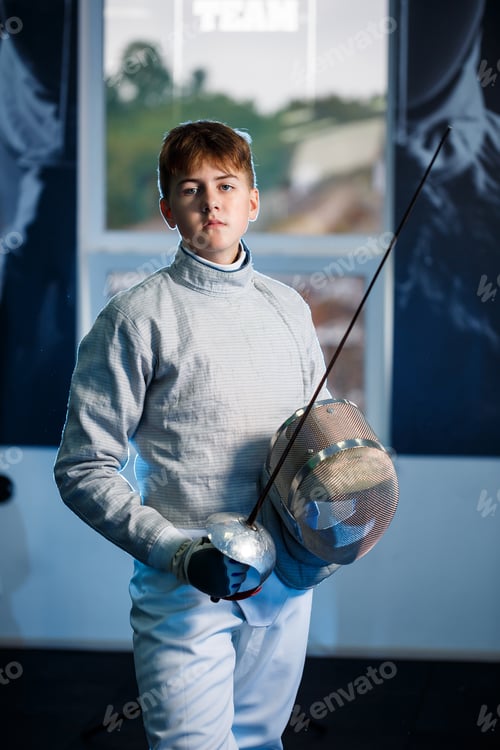 Preview: Child in a fencing suit with a sword in hand in the studio. Young boys practice