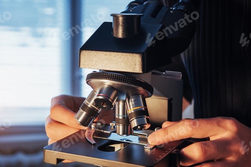 Preview: close-up of scientist hands with microscope, examining samples.