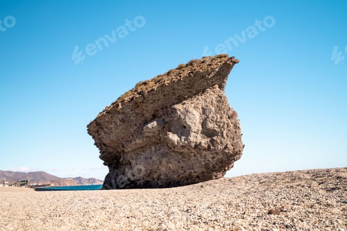 Preview: Weathered old rock formation isolated on background of the clear blue sky