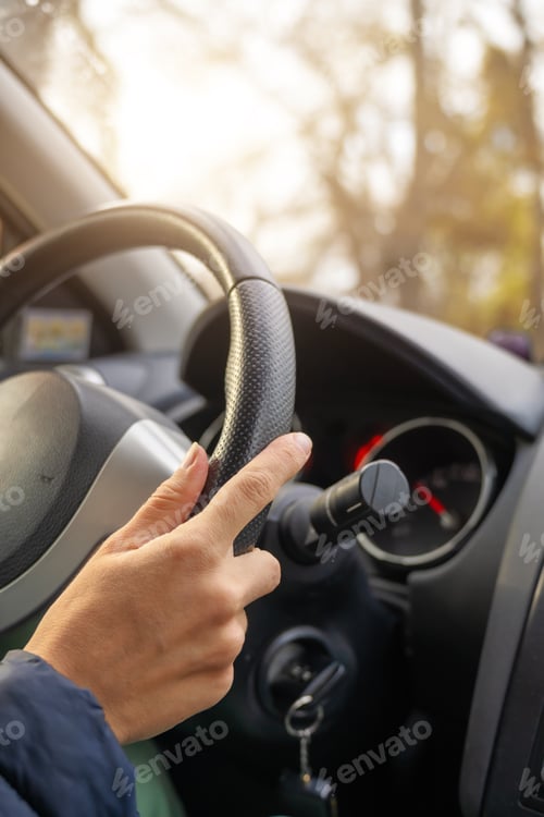 Preview: Lady hand holding steering wheel of car while driving.