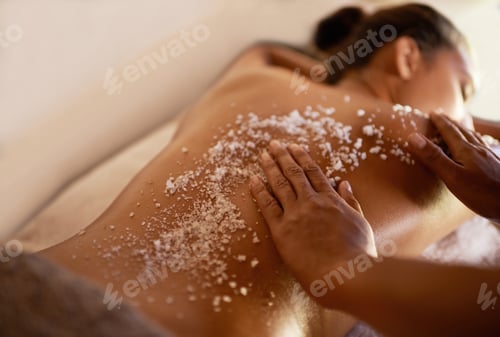 Preview: Shot of a young woman enjoying a salt exfoliation treatment at a spa