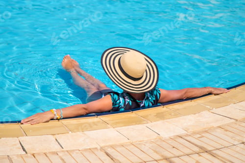 Preview: Woman in a hat in a swimming pool. Selective focus.