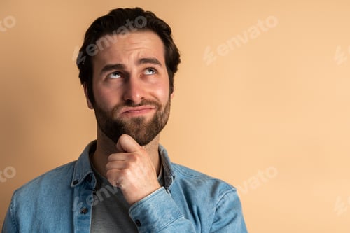 Preview: Thoughtful brunette man with beard holding his chin and pondering idea, confused about solution