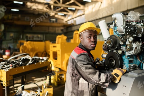 Preview: Young African American engineer in protective helmet looking at camera