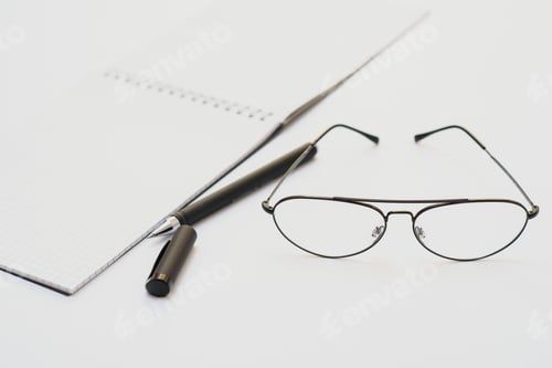 Preview: opened notebook with pen and glasses isolated
