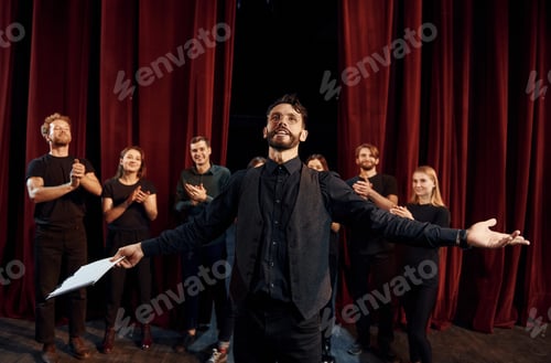 Preview: Group of actors in dark colored clothes on rehearsal in the theater