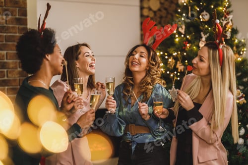 Preview: Four Multietnic Female Friends Having Fun And Make Toast As They Celebrate At Home Christmas Party