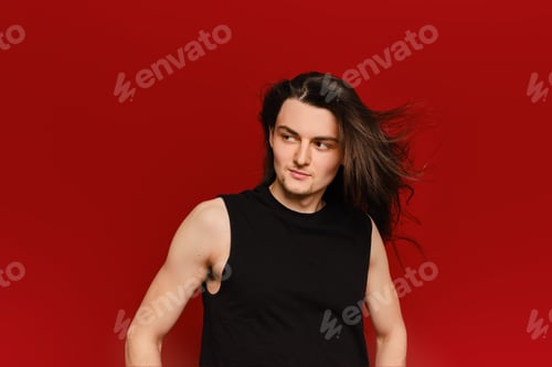 Preview: Studio portrait of young man with waiving long hair