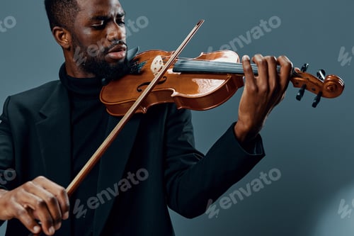 Preview: Elegant African American musician playing violin in black suit on neutral gray background, music
