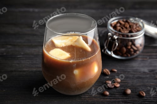 Preview: Coffee drink with milk ice cubes and beans on dark background