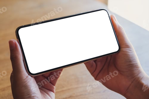 Preview: Mockup image of a hand holding a black mobile phone with blank white desktop screen