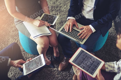 Preview: High angle shot of a group of businesspeople using their digital tablets