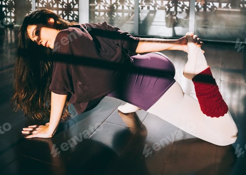 Preview: Ballerina dancer warming up flexible body in sunny studio.