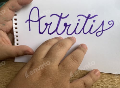 Preview: High angle shot of male hands and a sheet of paper with "Arthritis" text