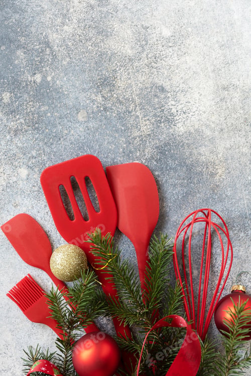 Preview: Various red kitchen baking utensils Christmas on gray stone background.