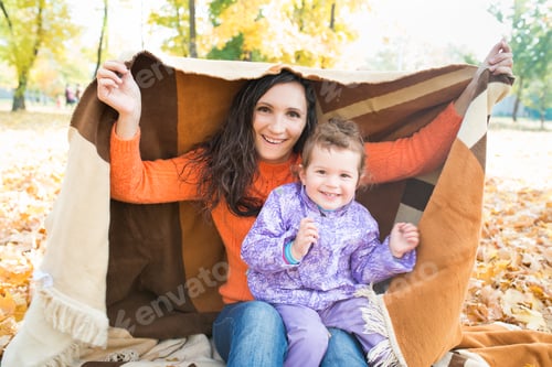 Preview: Cute cheerful young mother is covered with plaid