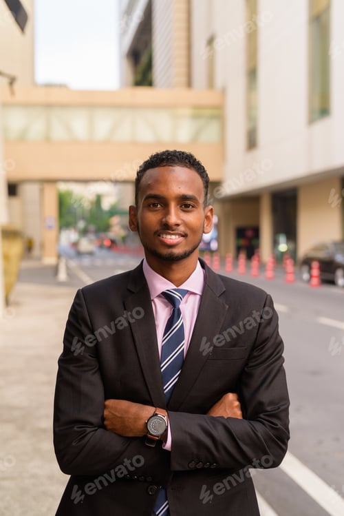 Preview: Portrait of handsome young African businessman outdoors in city