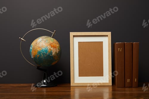 Preview: globe near blank frame and books on table