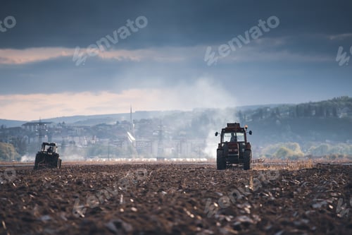 Preview: Tractors plowing fields in early spring
