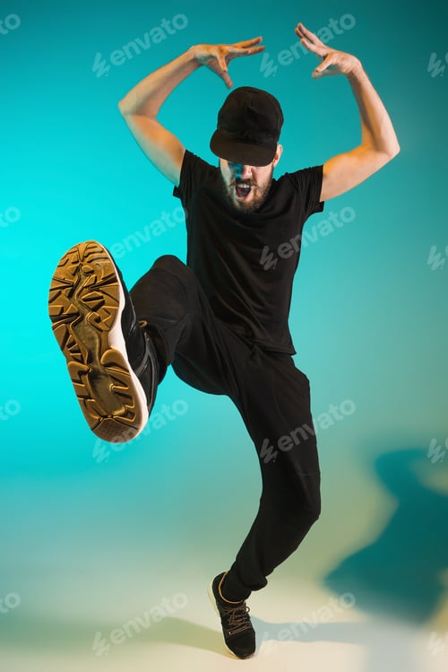 Preview: The silhouette of one hip hop male break dancer dancing on colorful background