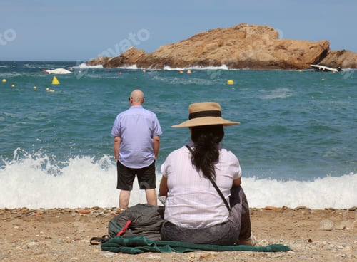 Preview: A couple looking at sea with hat and bald