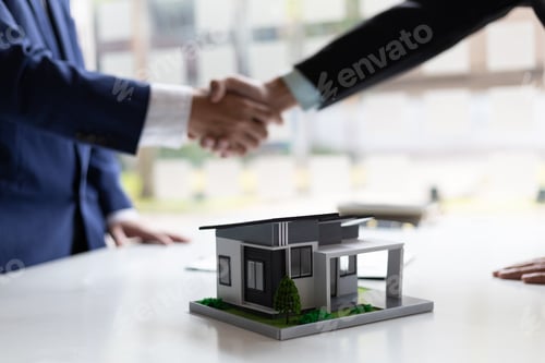 Preview: Businessman and real estate agent shaking hands after negotiating home purchase agreement.