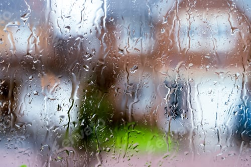 Preview: Rain drops on window glass with blurry house,Droplet surface texture of water on double glazed door,
