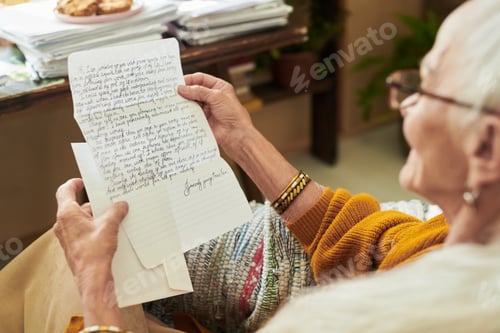 Preview: Elderly Person Reading Handwritten Letter by Desk