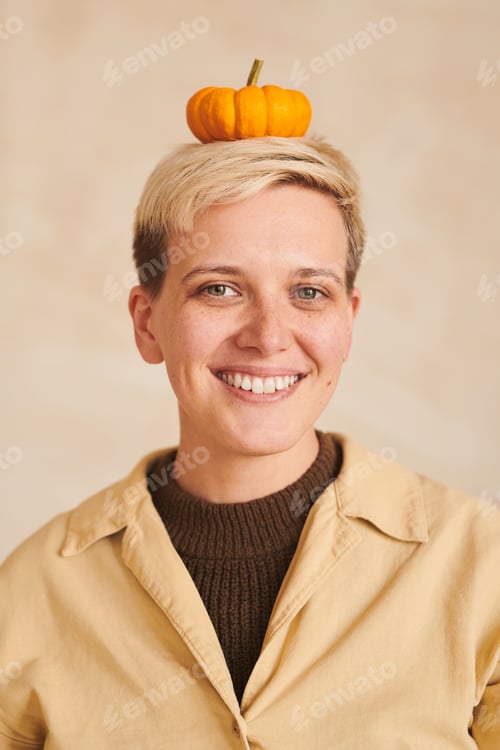 Preview: Portrait of girl keeping small pumpkin on head