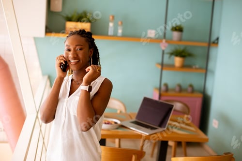 Preview: Young black woman using mobile phone in the cafe