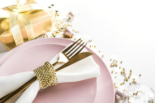 Preview: Christmas elegance table setting with pink dishware, golden silverware on white.
