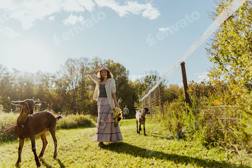 Preview: Rural life: Woman and goats in a sunny meadow, enjoying nature and freedom