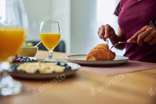 Preview: Close-up image of an unrecognizable female person enjoying a delicious breakfast.