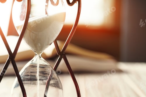 Preview: Closed up of sandglass or hourglass on background of book