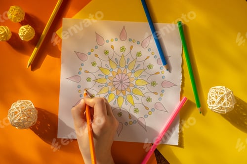 Preview: Woman coloring antistress page. Female hand painting mandala. Female painting mandalas to combat str