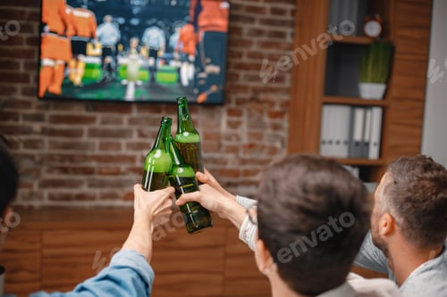 Preview: Cropped photo of a bottles of beer in men's hands watching a football game