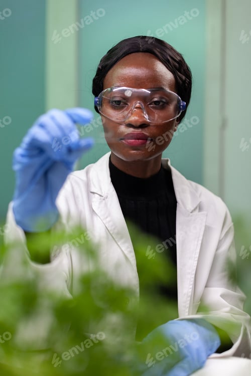 Preview: African american biologist woman holding green sample during biochemistry experiment