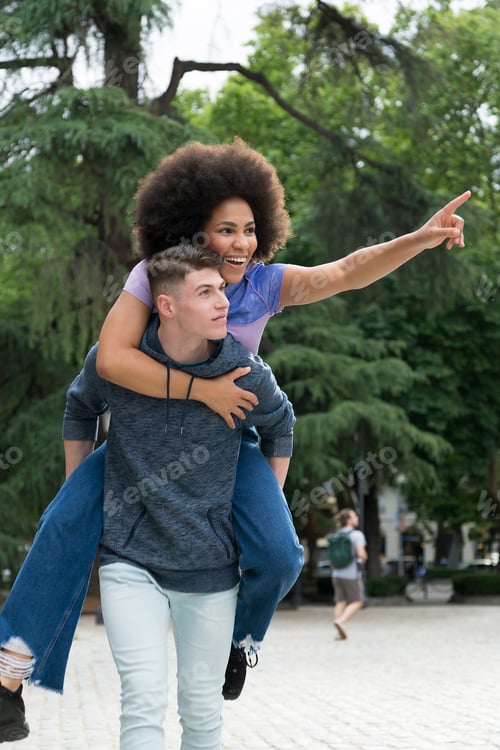 Preview: Caucasian boy carrying afro girl on his back having fun