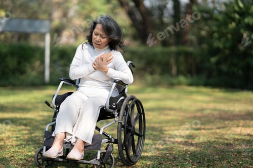 Preview: Asian Elderly grandmother with chest pain suffering from heart attack in wheelchair.